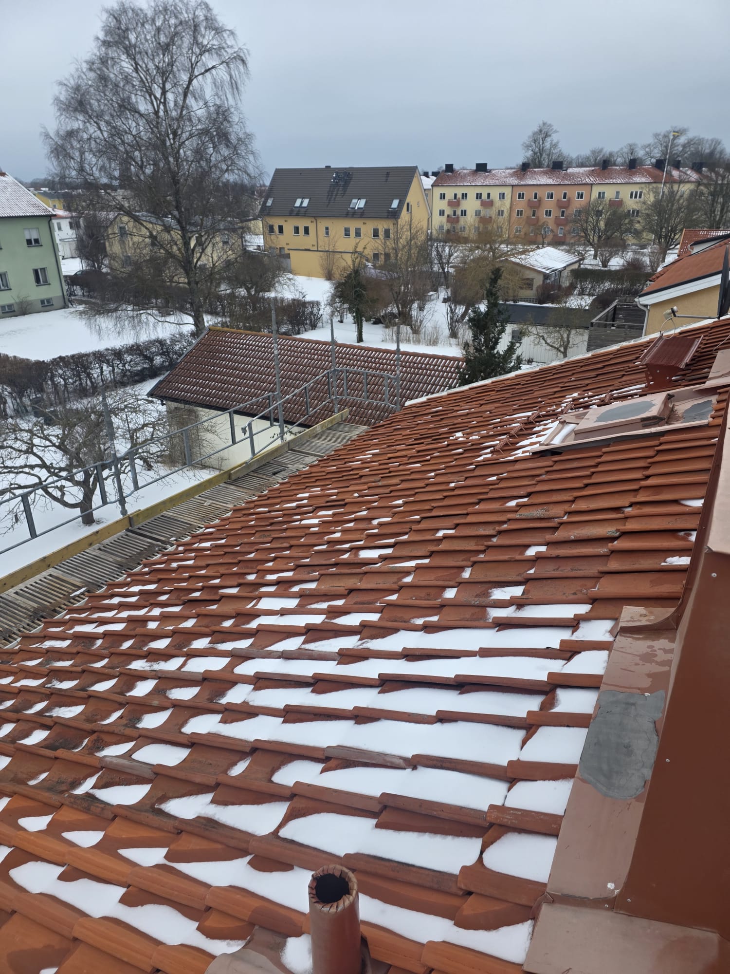 Taksiluett under pågående renovering med ställning och nya läkt i Visby