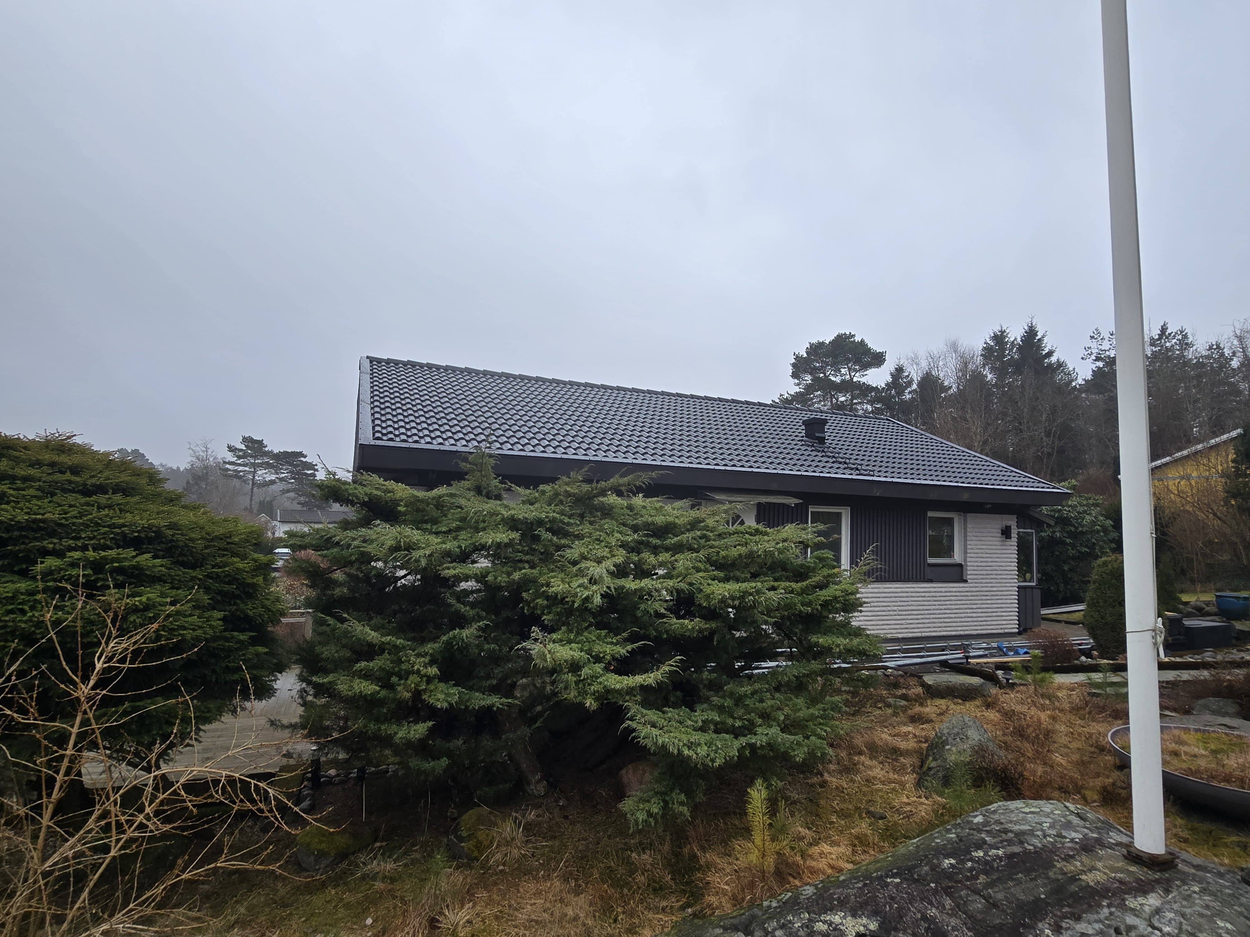 Takdetalj med läggning av nya betongpannor på villa i Onsala