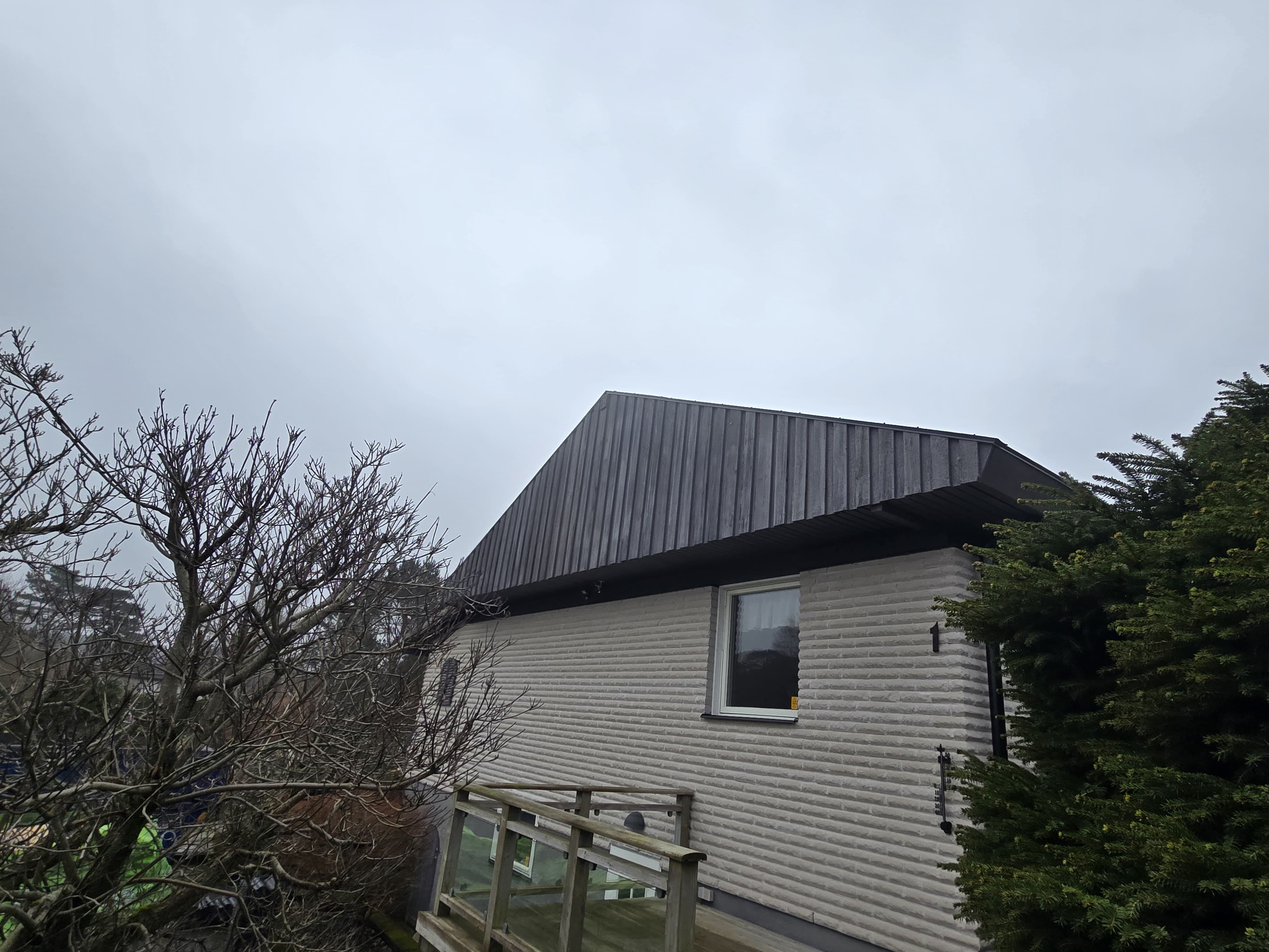Pågående läggning av betongpannor på villatak i Onsala