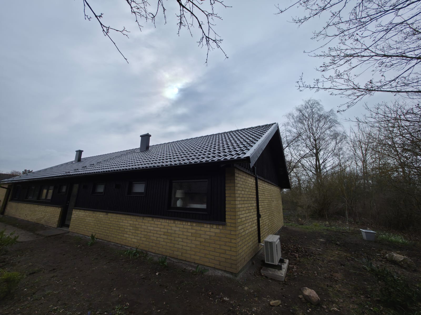 Nytt betongpannetak mot blå himmel på villa i Lund efter takomläggning