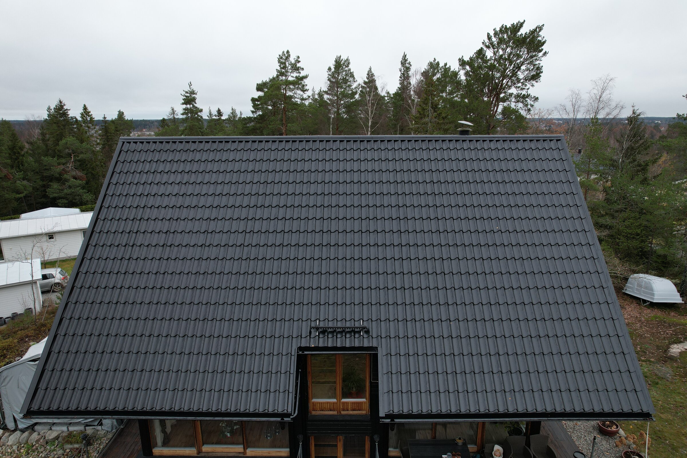 Drönarvy över ett nytt svart Plegel-tak med tegelprofil, monterat av Arbetslag Bygg