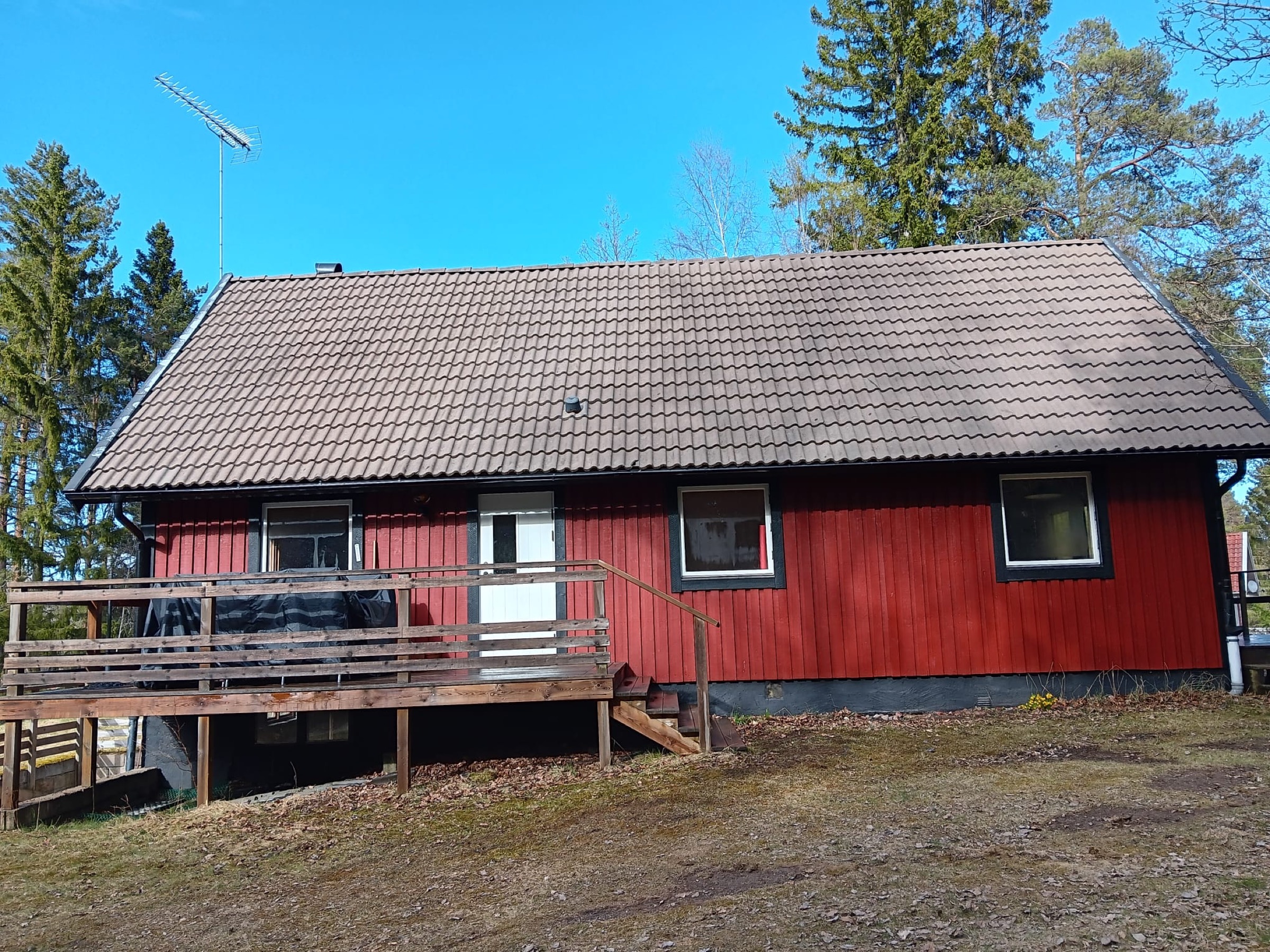 Rent, mörkt tegeltak på en röd villa efter taktvätt av Arbetslag Bygg